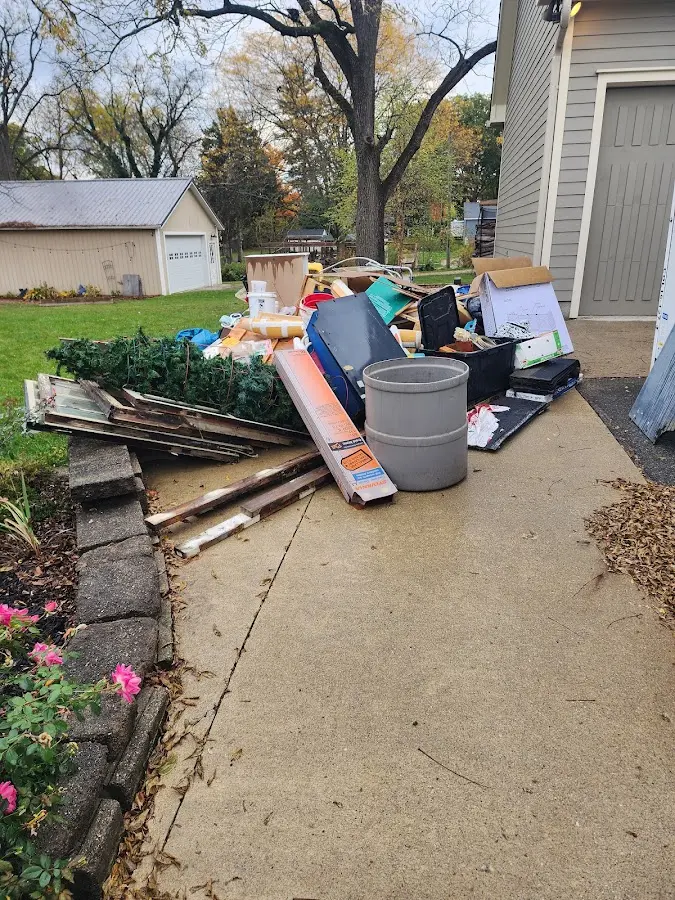 Dumpster being loaded with debris for 12 Yard Dumpster Rental in Harper Woods